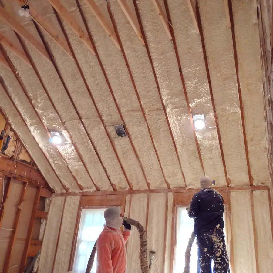 two men spraying insulation